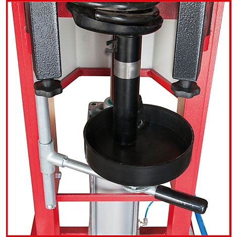 Detailaufnahme einer Stoßdämpfer-Spannvorrichtung. Schwarzer Stoßdämpfer, silberne Halterung, schwarze Plattform, roter Rahmen.